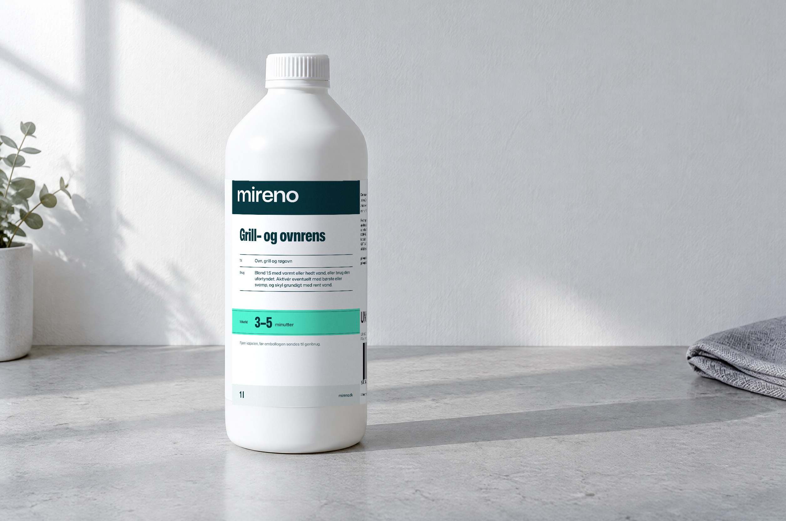 Grill- og ovnrens fra mireno, en 1 liter flaske, på en lys stenbordplade i vintersol (illustration: flasken er gengivet efter etiketten)